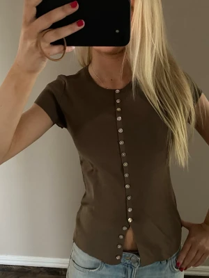 Topp med knappar  - En khaki färgad topp med knappar! 