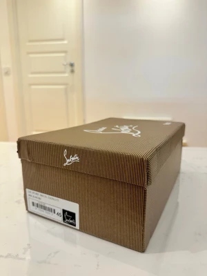 Skor - Säljer ett par exklusiva skor som är helt nya. Skorna är eleganta och levereras i sin klassiska randiga låda. Perfekt för dig som vill ha något lyxigt och stilrent i garderoben. På storleken 45.