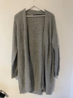 Grå lång kofta - Oanvänd kofta från lager 157. Inte för tjock i materialet och passar till massa olika outfits. 