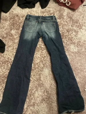 Gina Tricot jeans - Ett par jeans med fin detalj på båda fickorna där bak. Det är en mörkblåfärg på utsidan men in mot mitten så blir den ljus😊 Jeansen är i storlek 152 (barn)