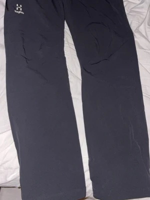 Haglöfs byxor  - Snygga mörkblå jeans med rak passform och klassisk denimlook. Perfekta för en stilren vardagsoutfit och lätta att matcha med olika toppar. Jeansen har en enkel design utan slitningar eller dekorationer.