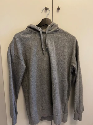 Grå hoodie från Mywear Woman XS - En klassisk grå hoodie från Mywear Woman i storlek XS. Hoodien har dragsko i huvan, ribbade muddar och är tillverkad i mjukt sweatshirtmaterial. Perfekt för en avslappnad och stilren look.