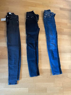 Tre par skinny jeans i olika färger - Säljer tre par skinny jeans i olika färger: ett par svarta, ett par mörkblå och ett par klassiskt blå jeans. Alla har femficksmodell och smal passform. Perfekta för dig som gillar en tajt siluett och vill variera din stil med olika tvättar.