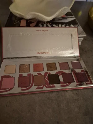 BUXOM ögonskuggspalett - Ögonskuggspalett från BUXOM med nyanser i rosa, brunt, guld, lila och nude. Paletten innehåller både matta och skimrande färger, perfekt för att skapa olika looks. Kommer i en rektangulär förpackning med spegel i locket. Testad,använd några gånger. Fin palett.  Bortglömd palett här tyvärr. Otroligt fina skuggor. 