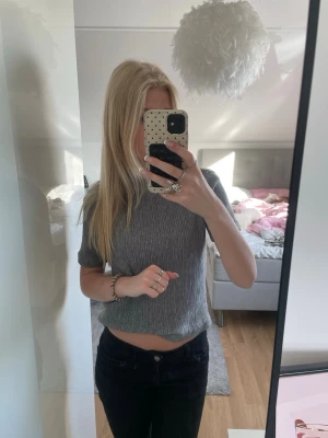 Grå ribbad kortärmad topp - Säljer en stilren grå ribbad topp med korta ärmar från Zara! Toppen har en kroppsnära passform och är tillverkad i ett mjukt, stretchigt material som ger en bekväm känsla.