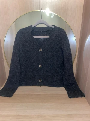 Mörkgrå kofta från 157 i storlek xs - Mysig mörkgrå kofta från 157 med tre knappar framtill och v-ringad hals i storlek xs. Koftan har långa ärmar och är tillverkad i ett mjukt, stickat material som passar perfekt för lager på lager. Enkel och stilren design som funkar till det mesta.skriv för fler bilder,pris kan diskuteras!💗