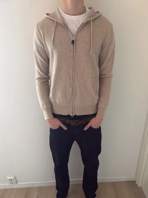 Beige cashmere zip-up  - Säljer en beige cashmere zip-up från sayless. Tröjan är i väl sparsamt skick och är i storleken XS, möjligtvis något större🤗Modellen på bilden är c.a 180cm! Passar dig som är 165-175 cm beroende på hur du vill att den ska sitta:) Hör av er vid minsta fundering!