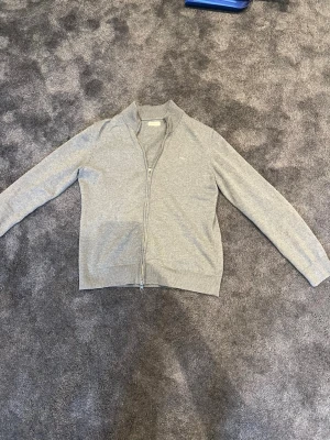 Ljusgrå gant tröja med zip - Jag säljer mina ljusgråa Gant tröja med hel zip. Tröjan har bra pass form och skön att ha på sig. Det är bra skick där den är väl använd och relativt ny. Passar perfekt till de mesta👌🏼!                   Storlek 176/16 år🙂                                                  Bud erbjuds vid intresse