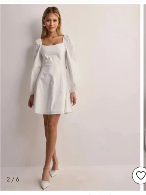 Vit kort klänning från Nelly - Slutsåld vit klänning från Nelly med fyrkantig urringning och långa puffärmar!!Använd vid ett tillfälle!!🤍🤍🤍