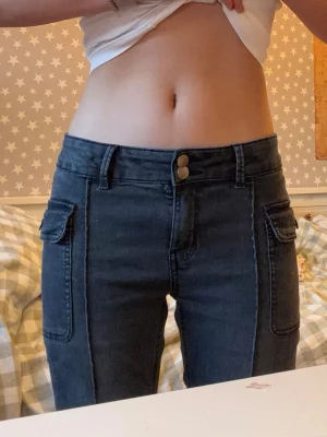 Low waist flare jeans med kostymsömmar - Grå flare jeans som liknar kostymbyxor, de har en kostymsöm i mitten och är väldigt stretchiga. Passar perfekt till vardagen som till fest och passar perfekt med nästan alla färger för dig som vill ha unika utsvängda jeans med en nästan vintagekänsla! passar alla upp till 170cm långa. innerbenslängd: ca 81 cm. Bra skick, har använts men passar inte längre mig. små färgfläckar som knappt går att märka. Skriv om ni vill ha mer bilder eller mått!!💗