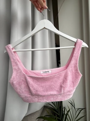 Rosa frotté linnetopp från Glamorous - Söt rosa linnetopp från Glamorous i mjuk frotté. Toppen är ärmlös med breda axelband och har en mycket croppad passform, ungefär som en sport-bh i storlek. Perfekt för sommarens varma dagar eller festival.