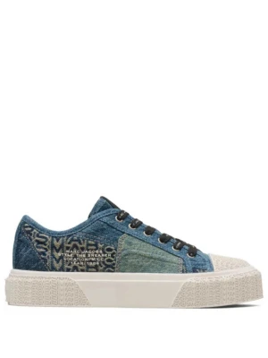Blå denim sneakers från Marc Jacobs - Unika sneakers i patchwork denim från Marc Jacobs med olika blå nyanser och vita detaljer. Skorna har svarta snören med logga, vit gummisula med mönster och tryckt text på sidan. Perfekt för dig som gillar streetwear och vill sticka ut.