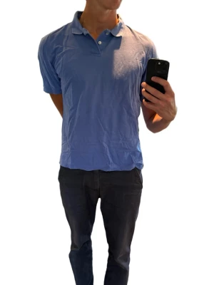 Lila golfpike  - Snygg lila pikétröja  med klassisk krage och två knappar framtill. Tillverkad i mjuk bomull som känns skön mot huden. Perfekt till jeans eller shorts för en avslappnad look.