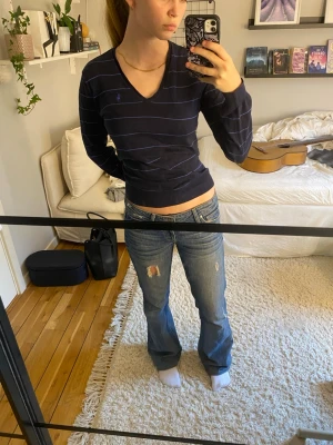 Långärmad tröja från Ralph Lauren - Säljer en långärmad, tunn, stickad tröja från Ralph Lauren. Den är mörkblå med blå streck och en v-ringning.