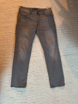 Gråa slim fit jeans från Produkt - Snygga gråa slim fit jeans från produkt med klassisk femficksmodell och normal midja. Jeansen har raka ben och diskreta sömmar, perfekta för en clean och modern look. Materialet är mjukt och stretchigt. Hör av dig om du har nån fråga💫