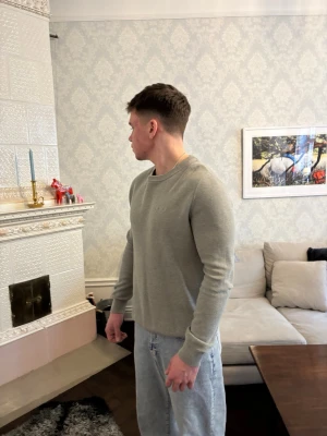 Grågrön stickad tröja herr - En stilren ljusgrågrön stickad med rund hals och långa ärmar. Den är i bra skick, nypris 900kr