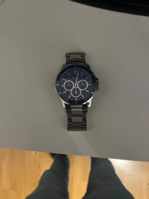 En snygg klocka med blått klock ur  - Inga skador,snygg att ha på sig,  låda och ett armband som tillhör kommer självklart med skriv för mer bilder på klockan,armbandet eller lådan. (Pris kan diskuteras)