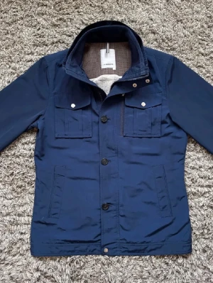 J.Lindeberg bailey field jacka - Snygg, J.Lindeberg bailey field jacket i mörkblå färg, passar perfekt till våren, sommaren och hösten. Inga defekter, stilren och eftertraktad. Nypris: ca 3500kr