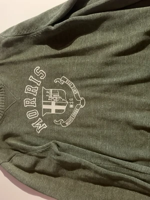 Grön tröja från Morris med tryck - Snygg grön tröja från Morris med vitt tryck och emblem på bröstet. Tröjan har rund halsringning, ribbade muddar vid ärmslut och nederkant samt lång ärm. Perfekt för en avslappnad men stilren look. Priset går att diskutera!