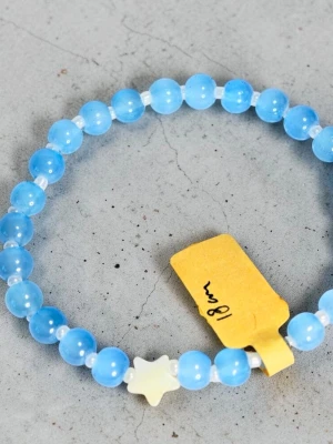 Blått pärlarmband med stjärna - Snyggt armband med runda, blå glas pärlor och små vita mellanpärlor. Armbandet har en söt vit stjärnformad pärla som detalj. Perfekt för dig som gillar färgglada accessoarer och vill sticka ut lite extra. Elastiskt band för enkel påtagning, 18cm