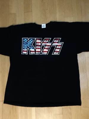Kiss T-Shirt | XL / Extra Large - T-Shirt med Kiss tryck på framsidan.  Fruit of The Loom - Heavy Cotton. Extra Large (Mått finns på bilderna!) 100% bomull.  Se bilder.
