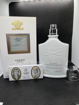 Creed Silver Mountain Water 100ml - Creed Silver Mountain Water är en exklusiv parfym i en elegant vit flaska med silverdetaljer. Flaskan rymmer 100 ml och har en stilren, modern design. Doften är inspirerad av friska bergsfloder och har en lyxig känsla. Perfekt för dig som gillar unika och fräscha parfymer.