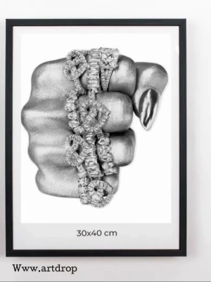 Svartvit konstposter 30x40 cm - Unik svartvit poster med motiv av en knuten hand dekorerad med detaljerade smycken och nagellack. Tryckt på vitt papper och inramad med svart ram. Perfekt som modern väggkonst för att ge rummet en cool vibe.