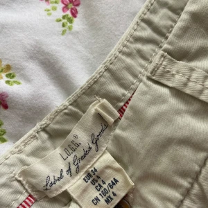 Beige shorts  -  beige shorts med klassisk passform och uppvikta benslut. Mjuk bomull 