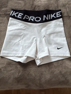Vita Nike Pro shorts med bred resår - Säljer Nike pros shorts då de inte kommer till användning! Storlek S, inte använda mer än 3 ggr.