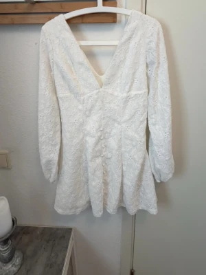 Vit spetsklänning med v-ringning - Söt vit klänning med v-ringning och långa ärmar. Klänningen har fina spetsdetaljer och ett lätt utställt fall. Perfekt för sommarens alla tillfällen och ger en romantisk känsla. Ordinarie pris:260kr den är helt ny så jag säljer den ganska nära ordinarie priset men något billigare 🫶🏼