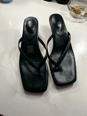 Svarta sandaletter  - Helt nya svarta sandaletter från shein med tunna remmar och fyrkantig tå. Sandalerna har en låg klack och är tillverkade i slätt konstläder. Perfekta för dig som gillar minimalistisk och trendig design.