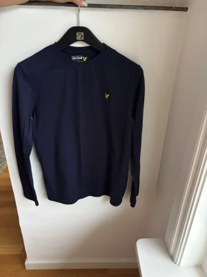 Mörkblå långärmad topp Lyle & Scott - Snygg mörkblå långärmad Lyle&Scott tröja i st 14-15 år för endast 99kr. Nypris 650kr