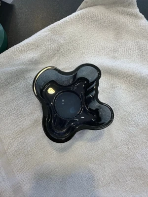Svart glasvas i organisk form från iittala - Säljer en stilren svart glasvas med vågiga, organiska former. Vasen har en blank yta och är tillverkad i tjockt glas. Perfekt som inredningsdetalj eller för blommor. Modern design som sticker ut och passar i de flesta rum. OBS: FRAKTAR INOM 24H!🩷