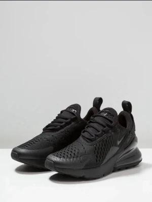 Nike Air Max 270 helsvarta sneakers - Nike Air Max 270 sneakers i helsvart med mesh- och syntetmaterial. Skorna har en chunky sula med synlig Air-enhet i hälen, ventilerande ovandel och klassisk Nike-logga på sidan. Perfekta för dig som gillar sportig och clean stil. Använt några gånger men ser helt nya ut, storlek 38, Dam och herr. Pris kan sänkas vid snabb affär 