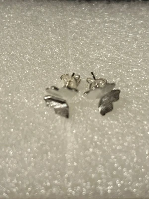 925 Silverpläterad ( stämplad) fjärilsörhängen - Säljer ett par stilrena örhängen i form av fjärilar i Silverpläterad , Örhängena har en matt och borstad yta som ger en modern känsla. Perfekta för dig som gillar minimalistiska accessoarer med en söt twist. Stiftmodell som är enkla att bära.  Finns ringar i samma stil 75kr/st 