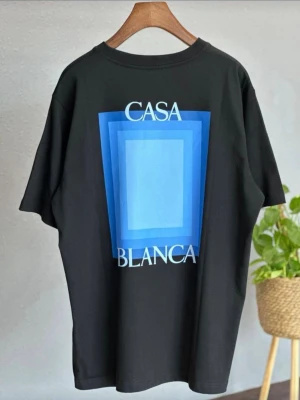 Svart Casa Blanca - Svart Casa Blanca t-shirt med stort tryck på ryggen. Riktigt clean men ändå snygg med blå detaljer som ger lite extra 🔥 Skön passform och lätt material, perfekt till vardag eller sommar. Helt ny.