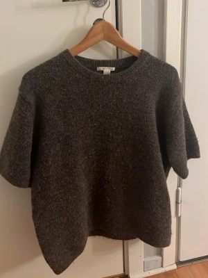 Stickad T shirt Gina - Mysig mörk brunstickad tröja från Gina Tricot med korta ärmar och rund halsringning. Tröjan har en lite luddig yta och är perfekt för lager-på-lager-stil. Enkel och stilren design som passar till det mesta.