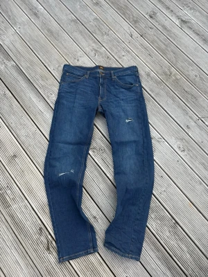 Blå Lee jeans med slitningar - Riktigt feta slimmade lee jeans, egengjorda slitningar, strl 33/32