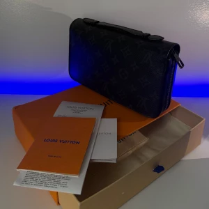 Louis Vuitton - Zippy Xl Wallet Monogram Eclipse - Säljer en exklusiv Louis Vuitton-väska som jag fick av min tjej sommaren 2024. Den har endast använts vid 8–9 tillfällen då jag sällan klär mig formellt på grund av jobbet. Väskan är i mycket bra skick.  Nypris i butik: 12 300 kr Mitt pris: 5995 kr  Ingår vid köp: 	•	Originalkartong 	•	Dustbag (påse) 	•	Kvitto 	•	Komplett dokumentation  Skicka meddelande vid intresse eller frågor! 