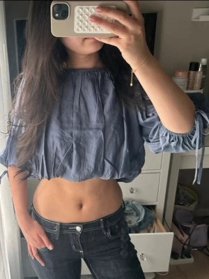 Blå croppad top - Säljer en jättefin blå croppad top med knytning på armarna!! Endast använd en gång 💙🥰🌸💕✨