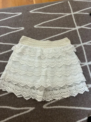 Vita spetsshorts - Säljer fina, volangförsedda spetsshorts i off-white. Det finns ingen storleksetikett, men de passar storlek S–M. Jag säljer dem eftersom de var lite för stora för mig. Utmärkt skick 🤍