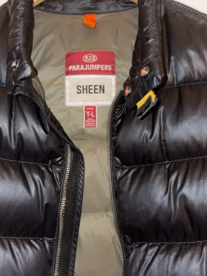 Parajumper väst - Säljer en parajumper väst som passar perfekt till höst och vinter med väldigt bra skick och inga skador. Storlek är Y-L med en perfekt passform som är stilren och glansig. Hör av dig vid funderingar!