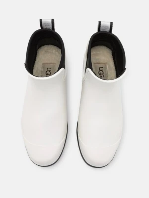 Vita stövletter från UGG - Snygga vita stövletter från UGG med svart sula och detaljer. Skorna har en rundad tå, dragflik med logga bak och mjukt foder inuti. Materialet är slätt och vattenavvisande, perfekt för regniga dagar. Modern och stilren design som sticker ut.