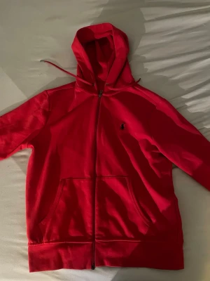 Röd hoodie från Polo Ralph Lauren - Snygg röd hoodie från Polo Ralph lauren. Använd 1-2 gånger, köpt från Johnells i Örebro. Extremt skön zip och skönt material, pris kan diskuteras !!! 