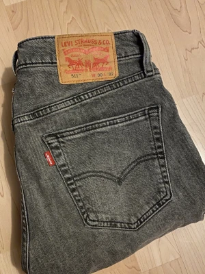 Grå Levi’s 512 Slim fit jeans - Snygga grå Levi’s jeans i modellen 512 (slim fit). Storlek W30 L32. Dragkedjan har hoppat ut från ena sidan, går nog o lösa lätt eller om man vill gå till en skomakare men de är inte något jag tagit tag i då dom ändå varit försmå. Postar inom 24h📦 Köp minst två plagg för 20% rabatt!🤝