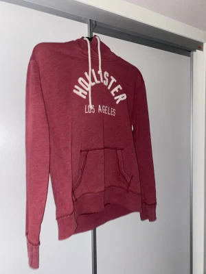 Vinröd hoodie från Hollister - Snygg vinröd tröja från hollister med vitt tryck med texten hollister Los Angeles. Hör gärna av dig om du är intresserad pris kan diskuteras!!