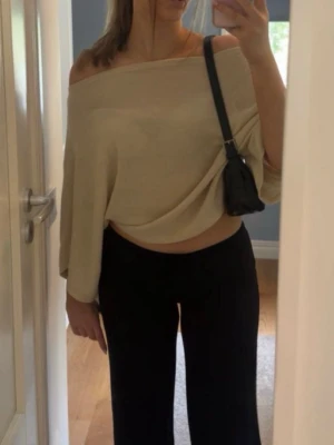 Beige poncho topp - Trendig beige topp med vida ärmar. Perfekt för dig som gillar en avslappnad men ändå snygg stil. Tunn och mjuk i materialet, lätt att matcha med olika outfits.