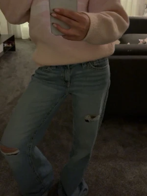 Blå lågmidjade baggyjeans från Gina tricot - Säljer ett par ljusblå jeans med raka ben och slitningar vid knäna. Jeansen har låg midja.