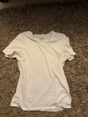 2-pack BOSS t-shirts i bomull - Säljer två klassiska t-shirts från BOSS, en i vitt och en i grått. Båda har rund hals, korta ärmar och diskret BOSS-logga på bröstet. Tillverkade i mjuk bomull för en skön och avslappnad look.