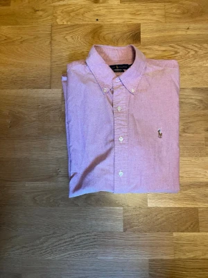 Rosa skjorta från Ralph Lauren - Riktigt schysst RL skjorta som är perfekt nu till våren och sommaren!  Det är custom fit passform. Ny pris ligger över 1000💵🍾Strl L. Kontakta mig vid minsta fråga  🌟